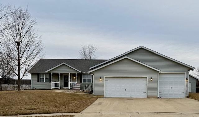 ranch-style house with driveway, a porch, an attached garage, and fence