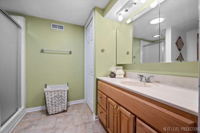 bathroom featuring vanity, tile patterned flooring, and a shower with shower door