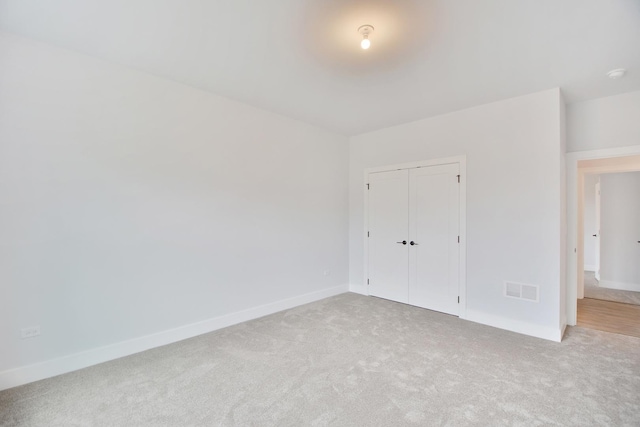 unfurnished bedroom featuring carpet floors and a closet