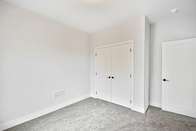 unfurnished bedroom with carpet flooring and a closet