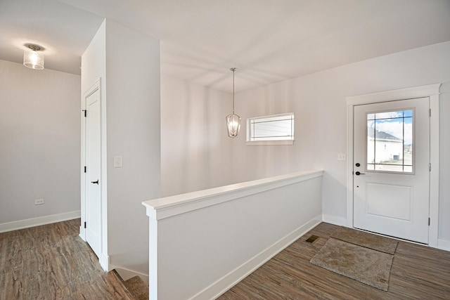 foyer featuring plenty of natural light, dark hardwood / wood-style flooring, and a notable chandelier