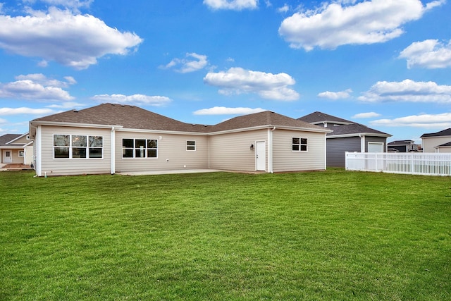 back of house with a lawn and a patio