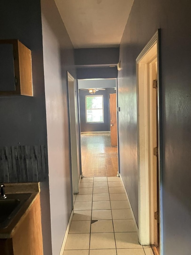 corridor featuring sink and light tile patterned floors