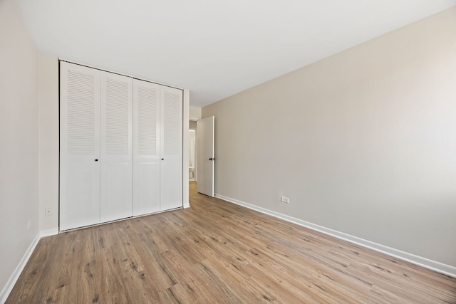 unfurnished bedroom with light hardwood / wood-style floors and a closet