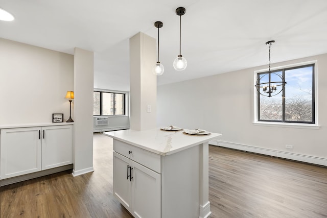 kitchen featuring hardwood / wood-style flooring, a baseboard heating unit, pendant lighting, and white cabinets