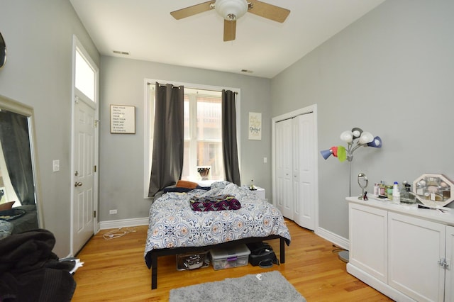 bedroom with multiple windows, a closet, and light hardwood / wood-style flooring