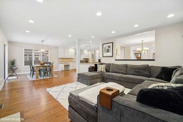 living room with a notable chandelier and light hardwood / wood-style flooring