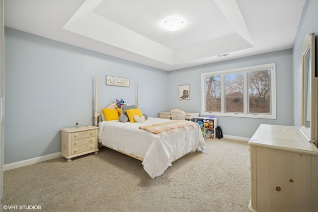 bedroom featuring a tray ceiling and carpet floors