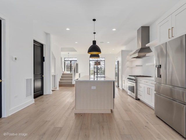 kitchen with stainless steel appliances, ventilation hood, white cabinets, and a kitchen island with sink