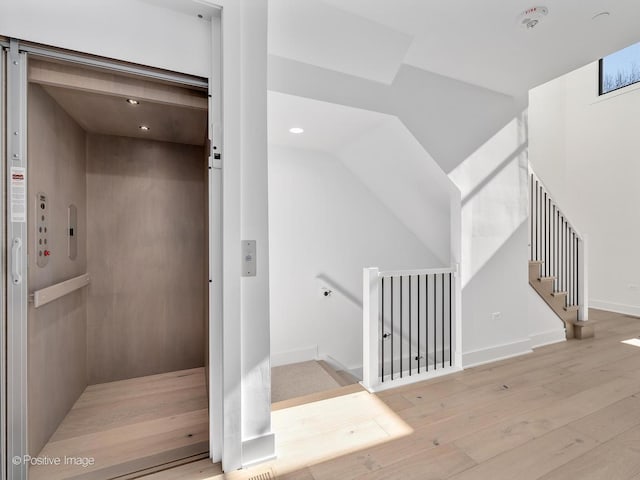 stairs with hardwood / wood-style floors and elevator