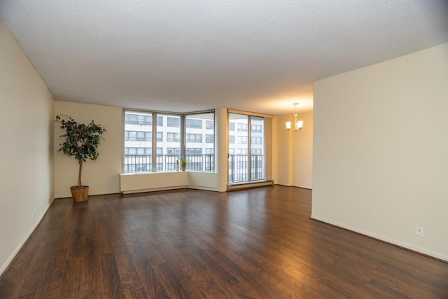 unfurnished room with dark hardwood / wood-style floors, a textured ceiling, and a chandelier