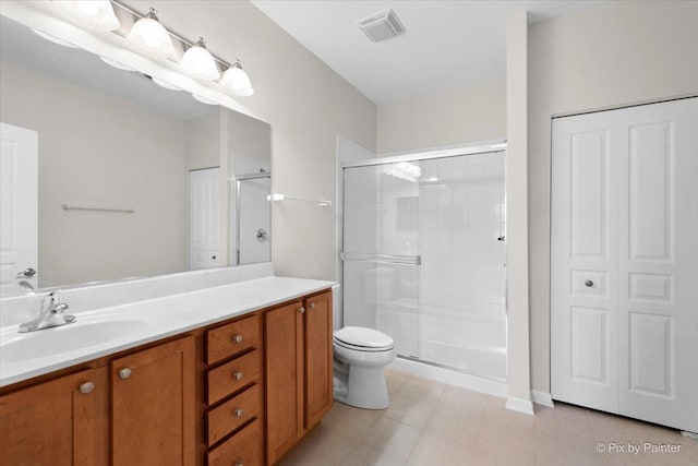 bathroom with vanity, tile patterned flooring, a shower with shower door, and toilet