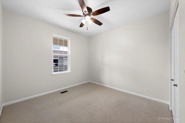 carpeted spare room with ceiling fan