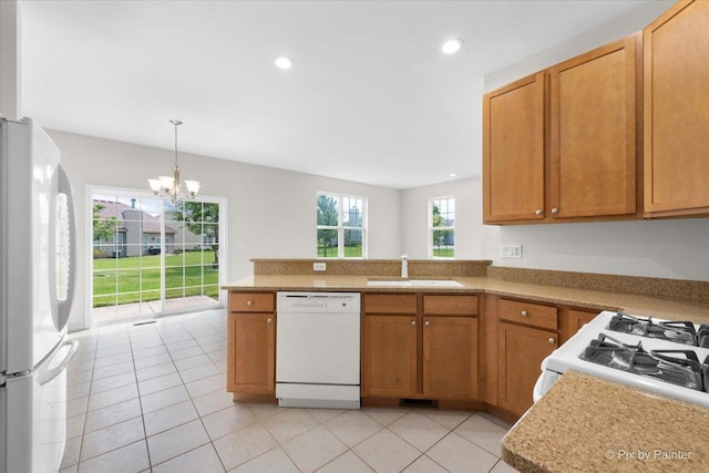 kitchen featuring sink, white appliances, kitchen peninsula, and light tile patterned floors