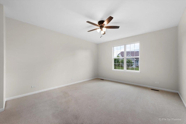 carpeted spare room featuring ceiling fan