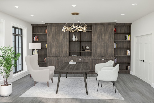 sitting room featuring a notable chandelier, hardwood / wood-style flooring, and built in features