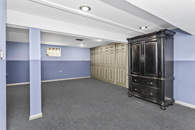 basement featuring dark colored carpet