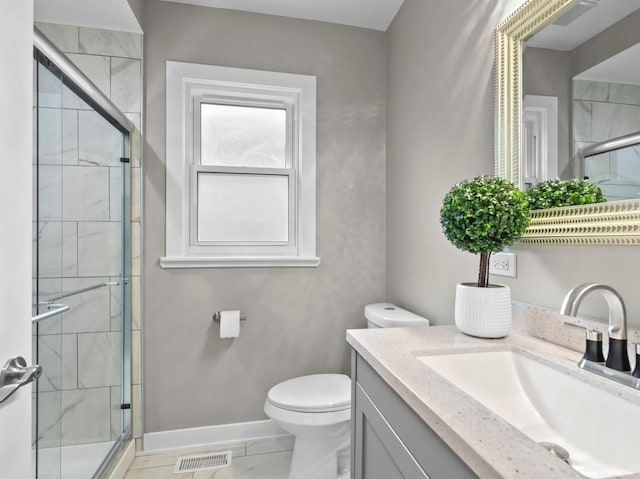 bathroom featuring vanity, a shower with shower door, and toilet