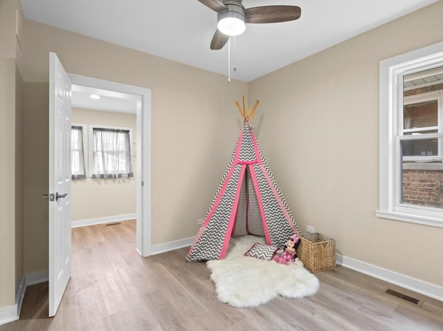 rec room featuring light hardwood / wood-style flooring and ceiling fan