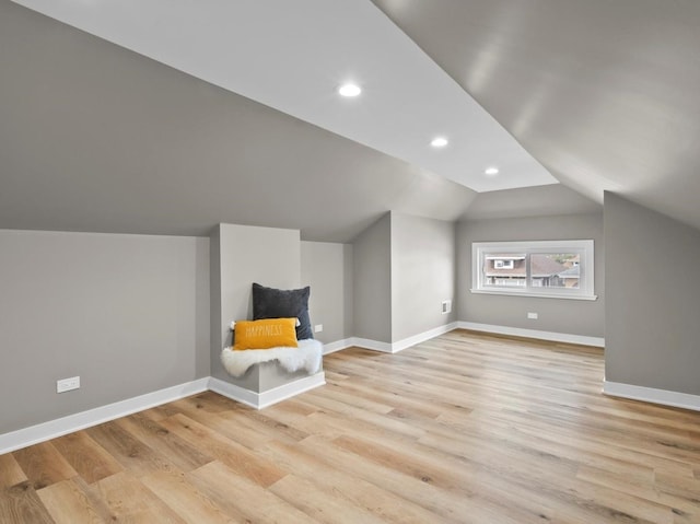 additional living space with vaulted ceiling and light hardwood / wood-style floors