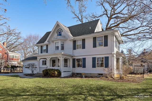 view of front of property with a garage, a front yard, and covered porch