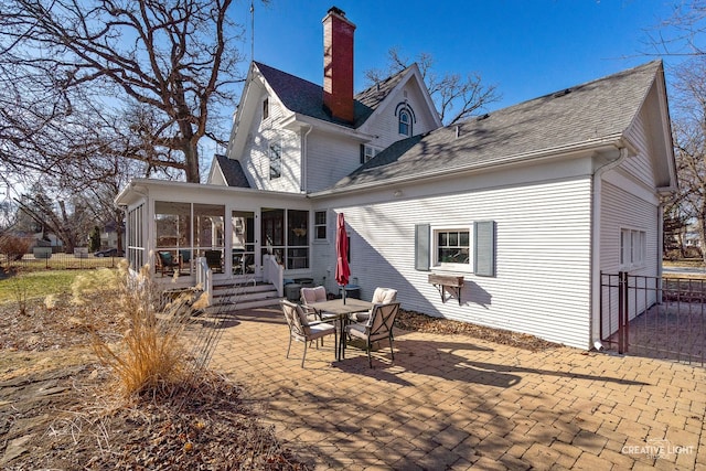 back of property with a patio area and a sunroom