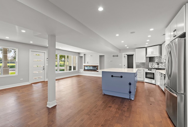 kitchen featuring white cabinetry, dark hardwood / wood-style flooring, a center island, and appliances with stainless steel finishes