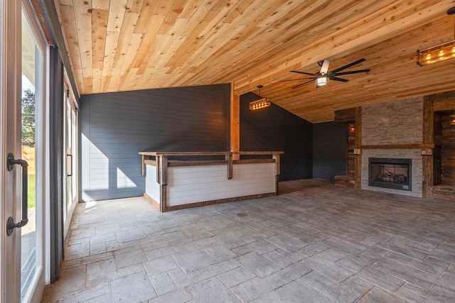 unfurnished living room with ceiling fan, lofted ceiling, an outdoor stone fireplace, and wooden ceiling