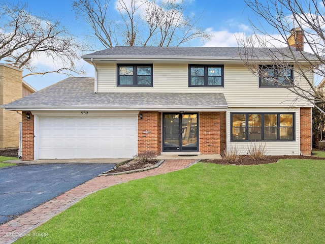 view of front facade featuring driveway, an attached garage, a front lawn, and brick siding