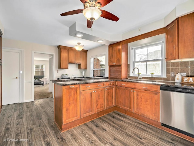 kitchen featuring dishwasher, dark wood-style flooring, a sink, and backsplash