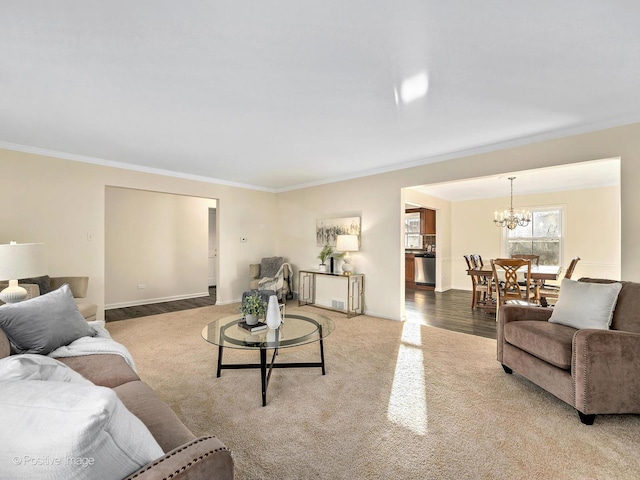 living area with carpet, baseboards, ornamental molding, and a notable chandelier