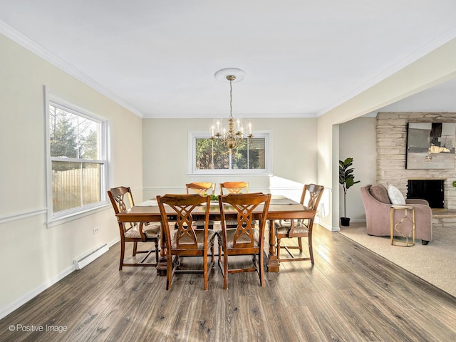 dining space with baseboards, a baseboard radiator, wood finished floors, and crown molding