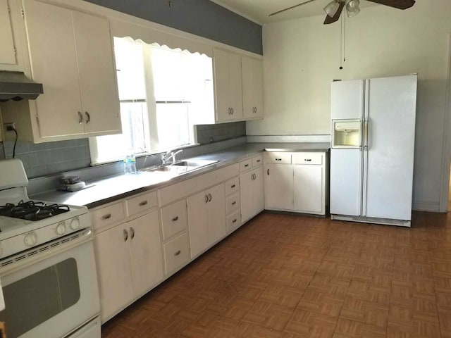 kitchen featuring light countertops, white cabinets, a sink, white appliances, and under cabinet range hood