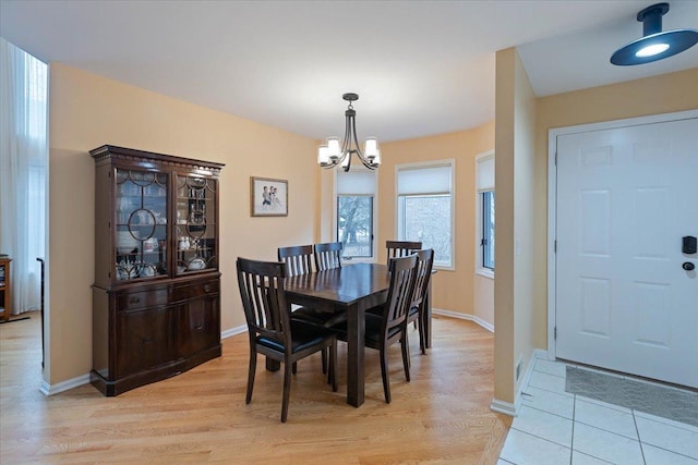 dining room with light hardwood / wood-style floors and a notable chandelier