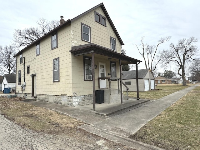 view of front of home with cooling unit, a garage, a front yard, and an outbuilding