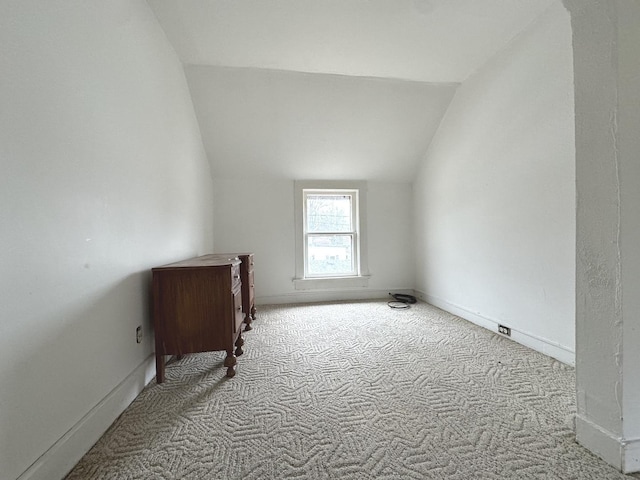 empty room with vaulted ceiling and light carpet