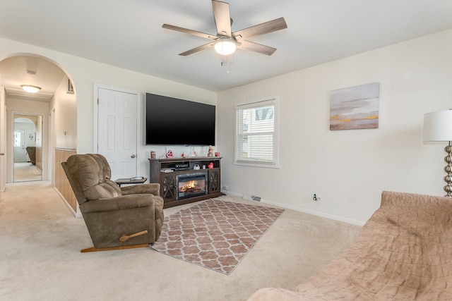 carpeted living room with ceiling fan