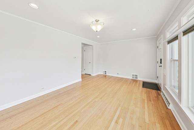 spare room with crown molding and light hardwood / wood-style flooring