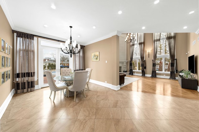 dining room with crown molding, a fireplace, baseboards, and an inviting chandelier