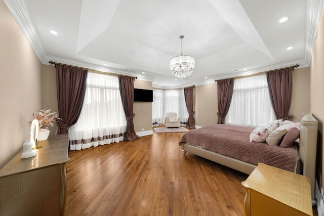 bedroom with crown molding, a raised ceiling, wood finished floors, and recessed lighting