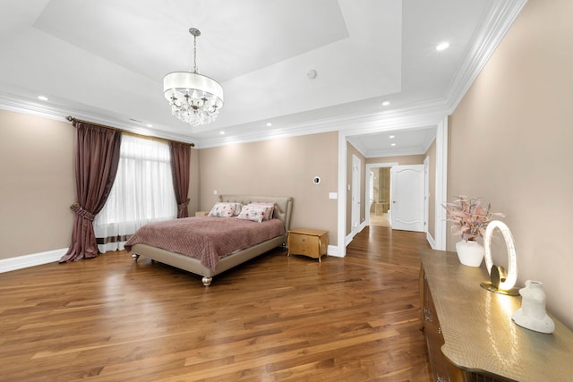 bedroom with a tray ceiling, recessed lighting, wood finished floors, and baseboards