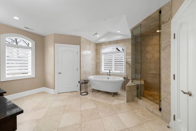 bathroom with a freestanding tub, recessed lighting, visible vents, baseboards, and a tile shower