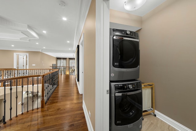 laundry room with recessed lighting, stacked washer / dryer, wood finished floors, laundry area, and baseboards