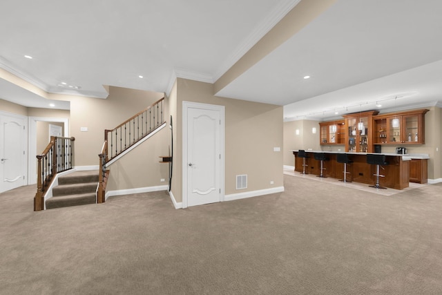 living room featuring visible vents, baseboards, stairs, indoor wet bar, and crown molding