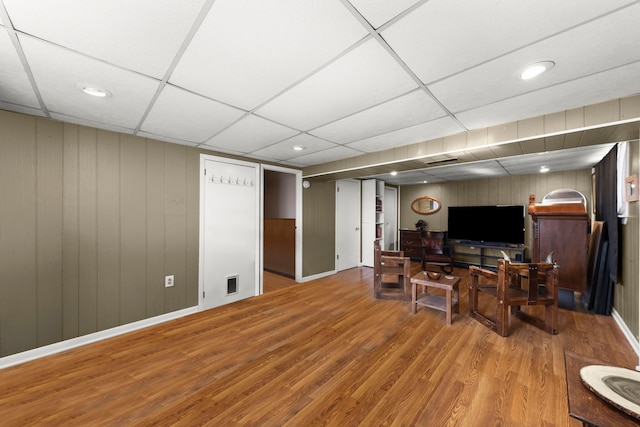 living room with a drop ceiling and hardwood / wood-style flooring