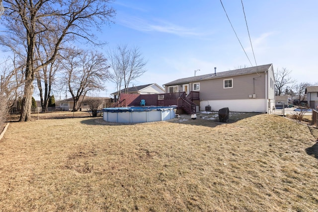 back of house featuring a pool side deck and a lawn