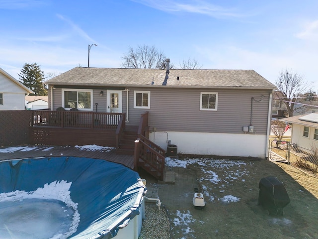 rear view of property featuring a pool side deck