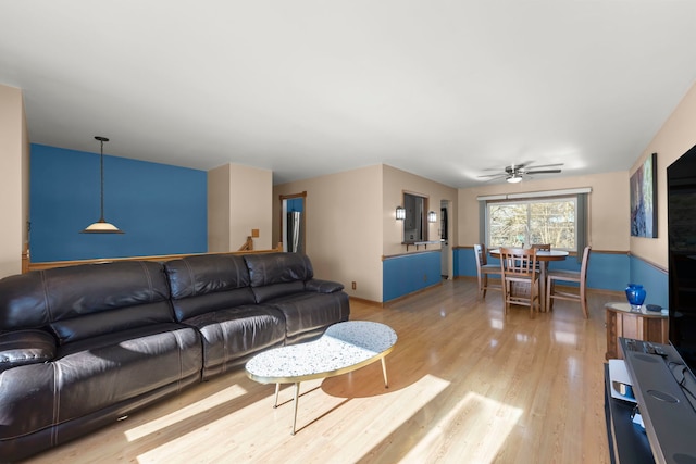 living room with wood-type flooring and ceiling fan