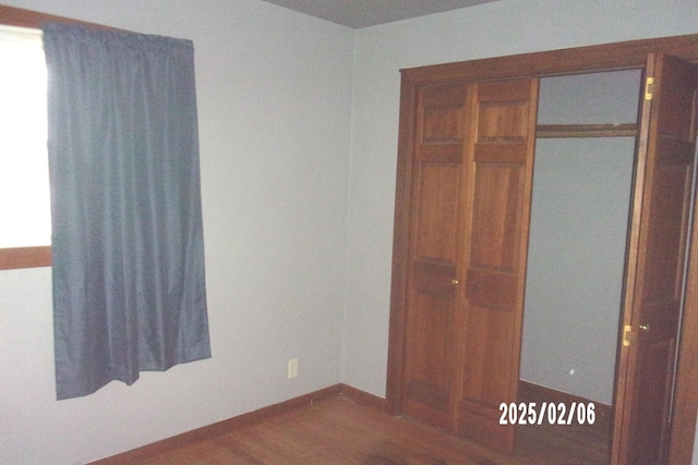 unfurnished bedroom featuring dark hardwood / wood-style floors and a closet