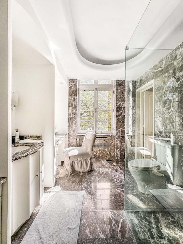 interior space with vanity, a washtub, and a raised ceiling